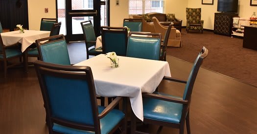 A cozy dining area with a table and blue chairs, ready for guests.