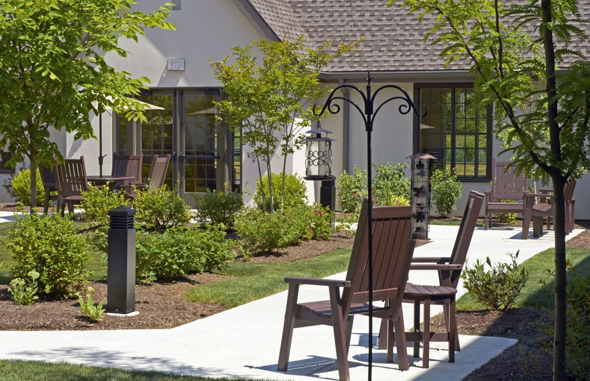 A serene outdoor patio area with chairs and lush landscaping.
