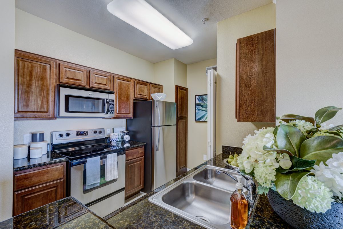 A modern kitchen with wooden cabinets and stainless steel appliances.