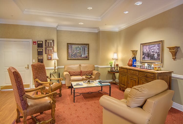 A cozy living room with comfortable seating, artwork on the walls, and warm lighting.