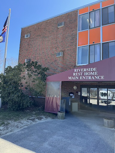 The main entrance of Riverside Rest Home, featuring the flag and signage.