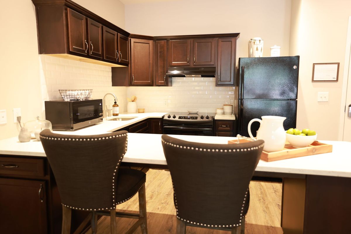 A modern kitchen interior with dark wood cabinets and a breakfast bar.