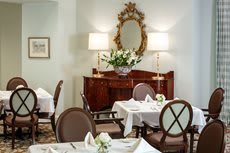 An elegantly decorated dining room with set tables and classic furnishings.