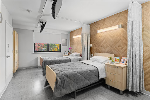 A modern bedroom featuring twin beds, stylish wood paneling, and contemporary decor.