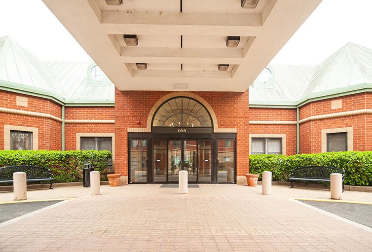 Entrance of a hospital, featuring brick architecture and a welcoming walkway.