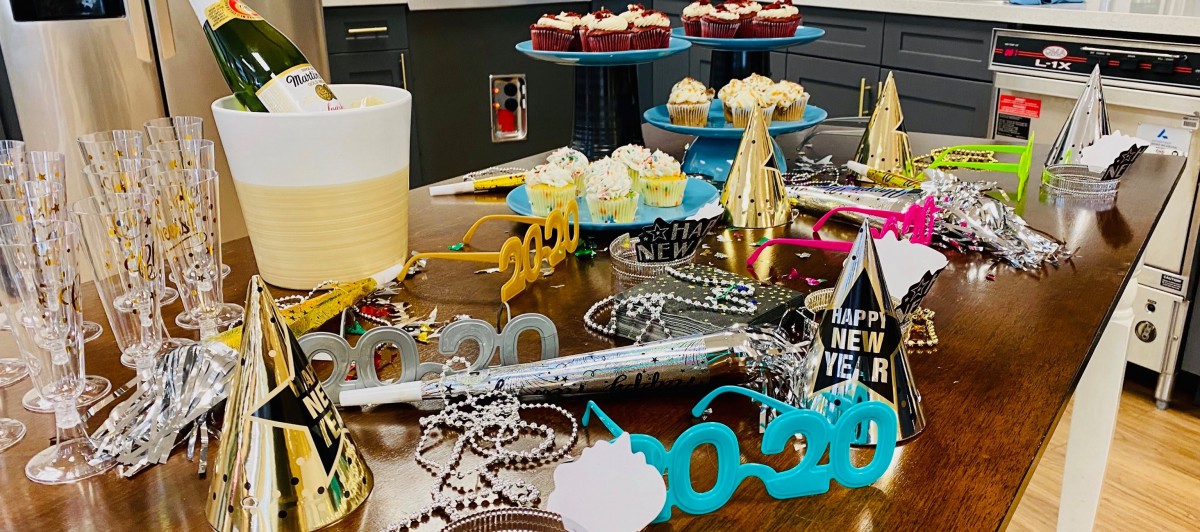 A festive table set for a New Year's celebration with cupcakes and decorations for the year 2020.
