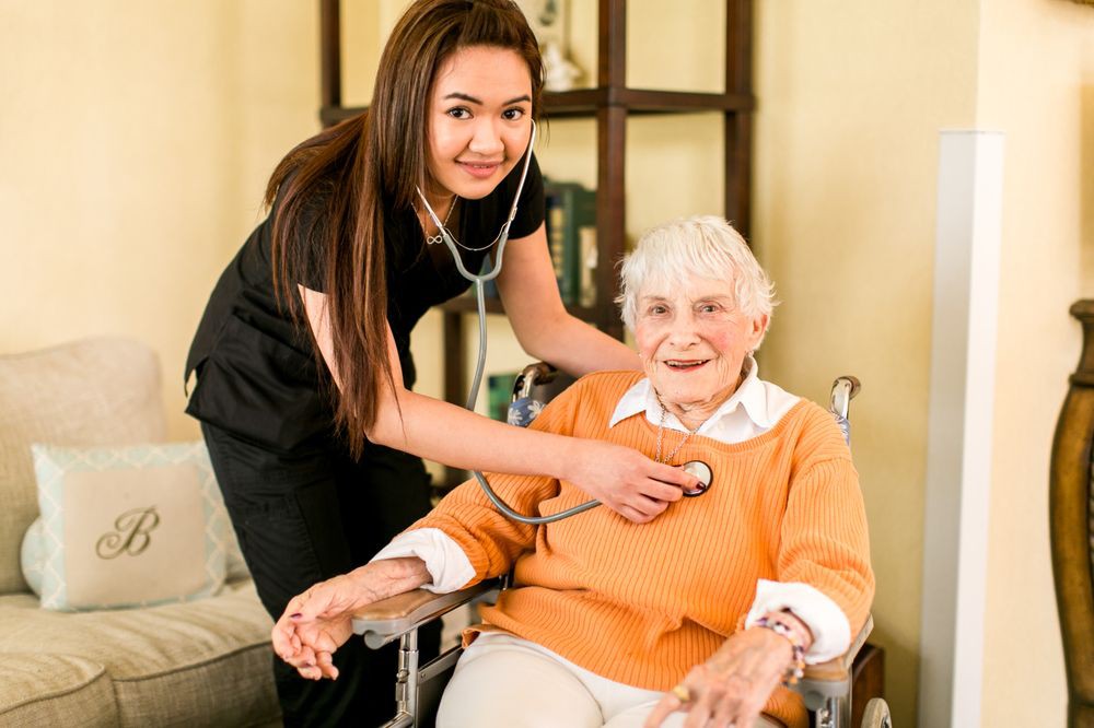 A nurse uses a stethoscope to examine an elderly woman in a healthcare setting.
