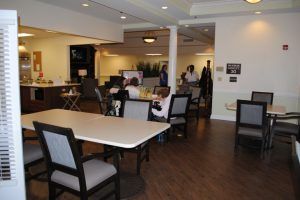A modern dining area with tables and chairs, where people are gathering.