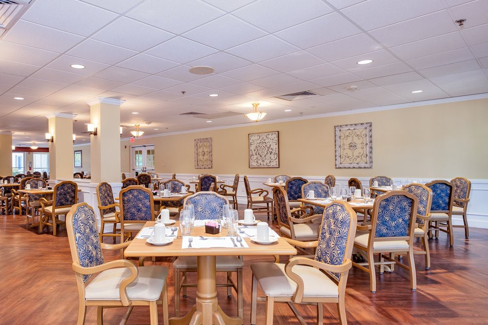 A spacious and elegantly decorated dining room with neatly arranged tables and chairs, ready for guests.
