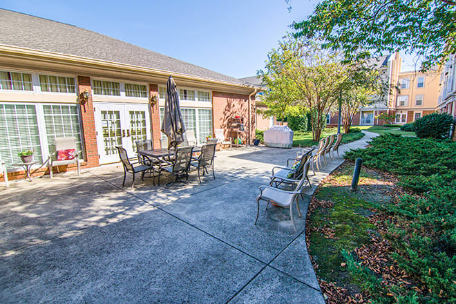 A spacious patio area with outdoor seating and a well-maintained garden on a sunny day.