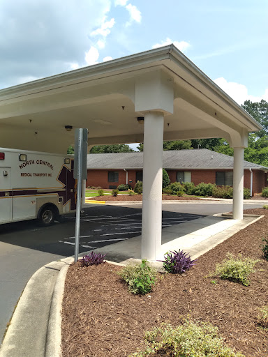 An ambulance parked under a covered area at a healthcare facility.