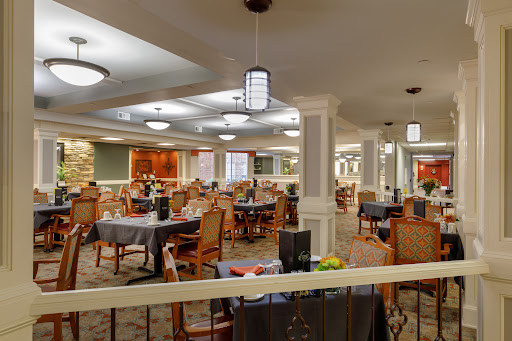 A spacious and elegantly designed dining area with a blend of modern decor and comfortable seating.