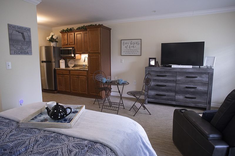 A cozy studio apartment with a kitchenette and living area.