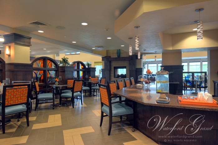 A modern restaurant interior with dining tables and chairs arranged neatly.
