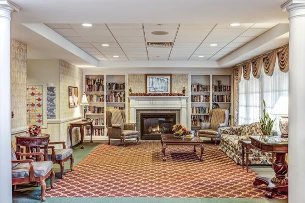 A cozy living room with a fireplace and bookshelves.