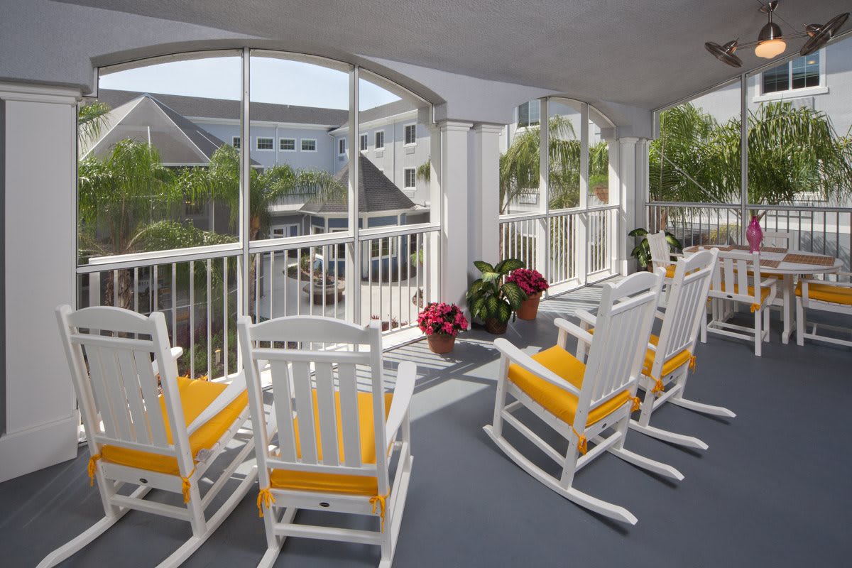 A cozy porch with white rocking chairs and vibrant flower pots, offering a serene outdoor escape.