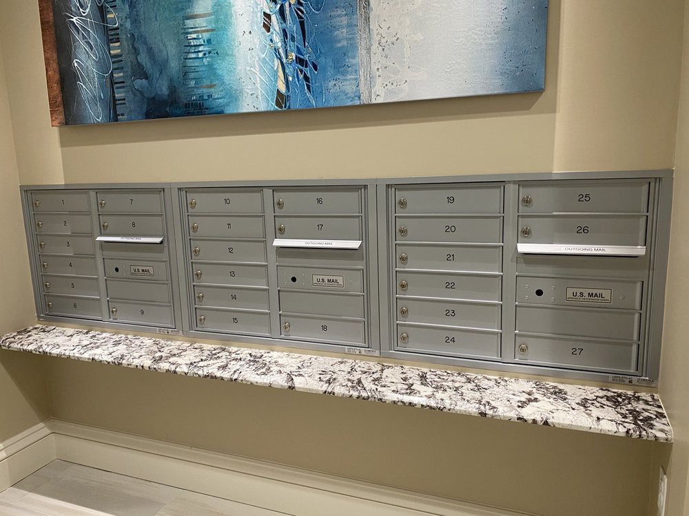 Wall-mounted mailboxes in an indoor setting.
