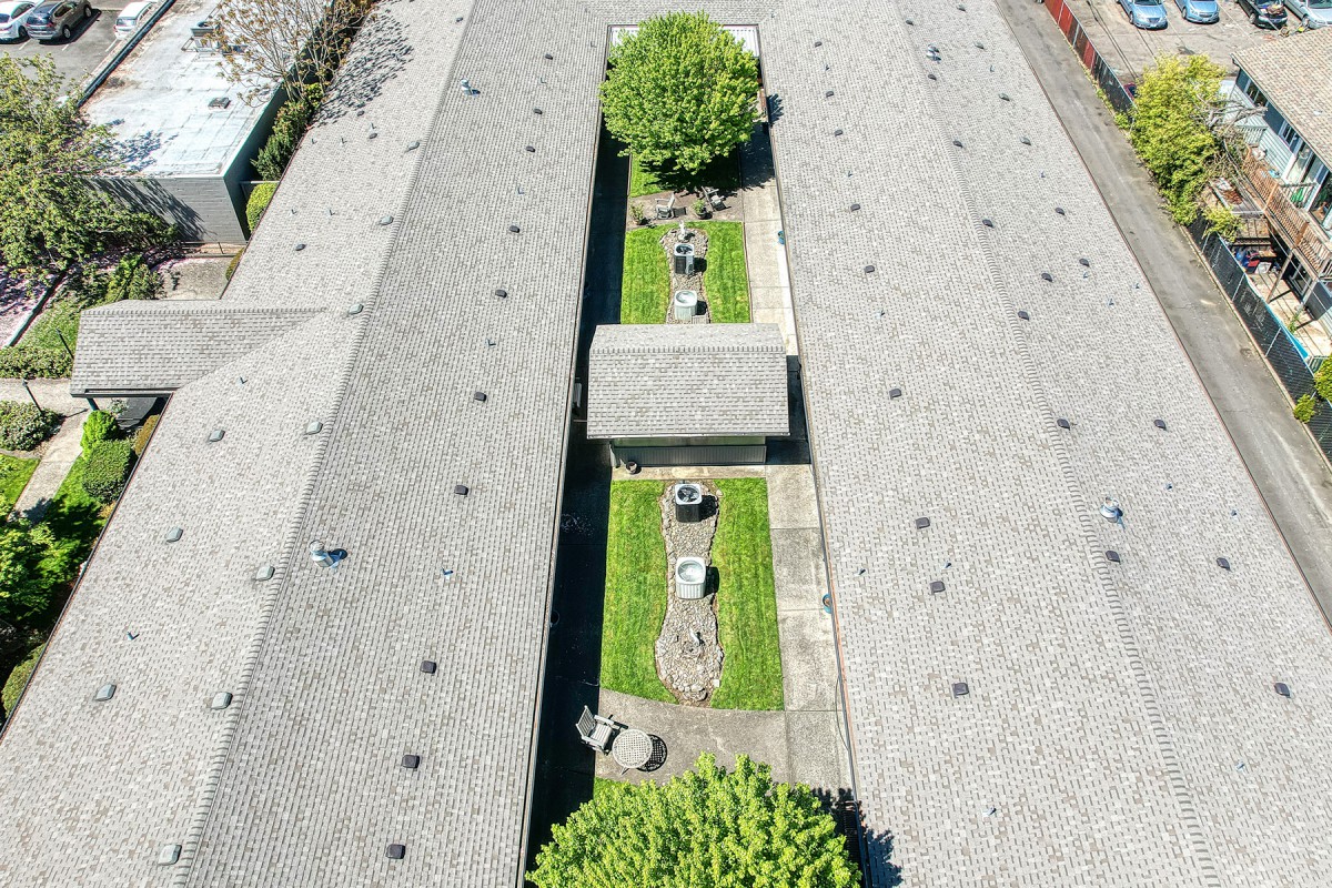 Aerial view of a rooftop garden with trees and green spaces on an urban building.