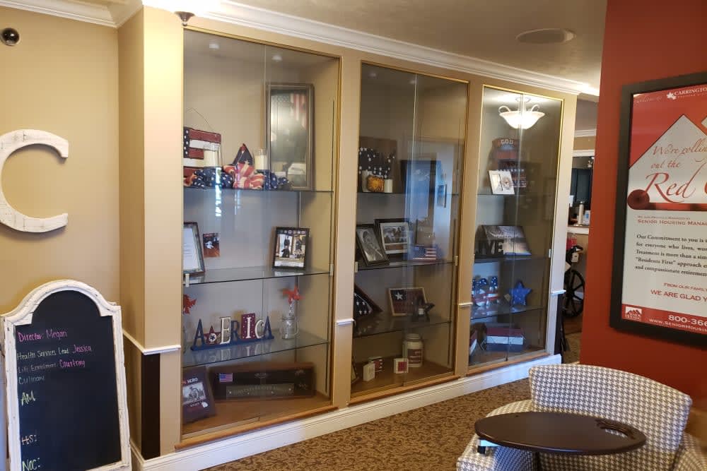 A glass display case showcasing various trophies and memorabilia in an interior setting.