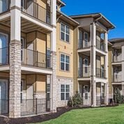 A modern apartment building with multiple balconies and a well-maintained exterior.