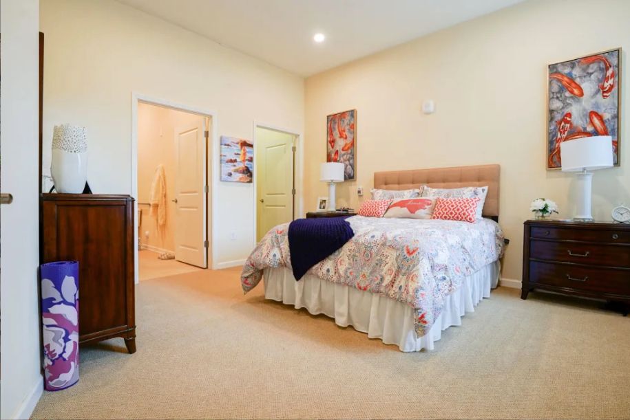 A cozy bedroom with a neatly made bed, soft lighting, and warm decor.
