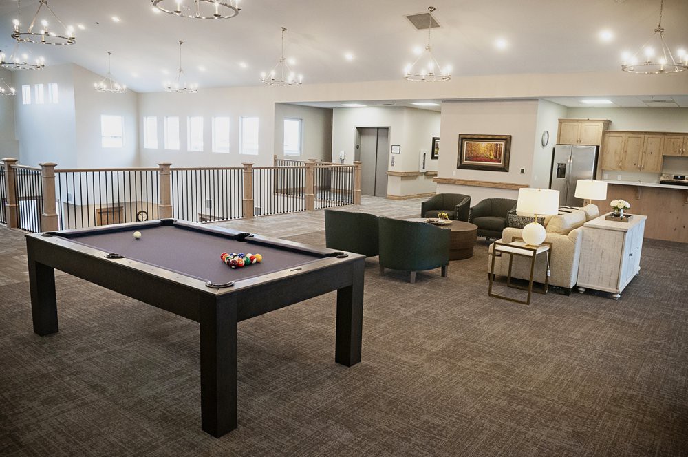 A modern lounge area featuring a pool table and comfortable seating.