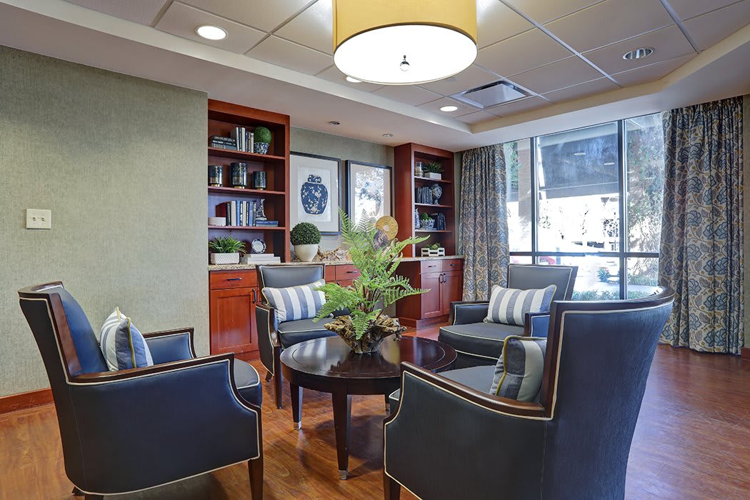 Stylish lobby area featuring comfortable seating, a central table with a plant, and bookshelves in the background.
