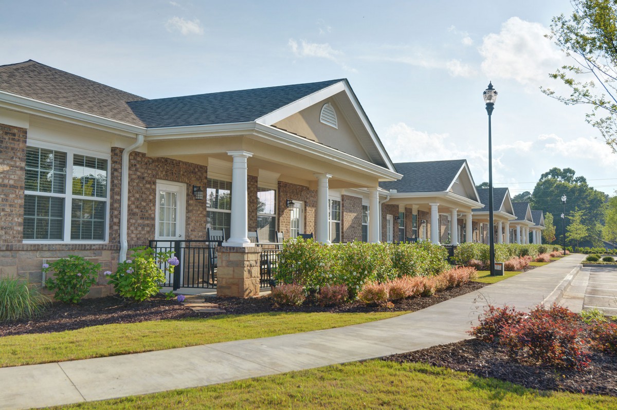 A row of suburban houses with front porches in a neighborhood setting.