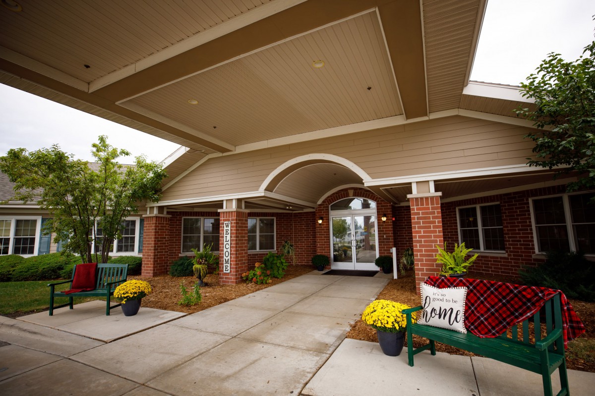 Main entrance of a building with a covered walkway and decorative landscaping.