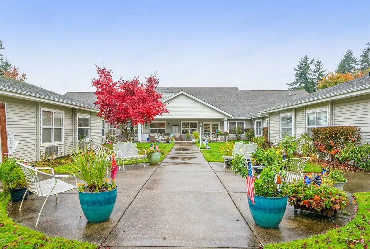 A beautifully landscaped courtyard with potted plants and a pathway leading to a building.