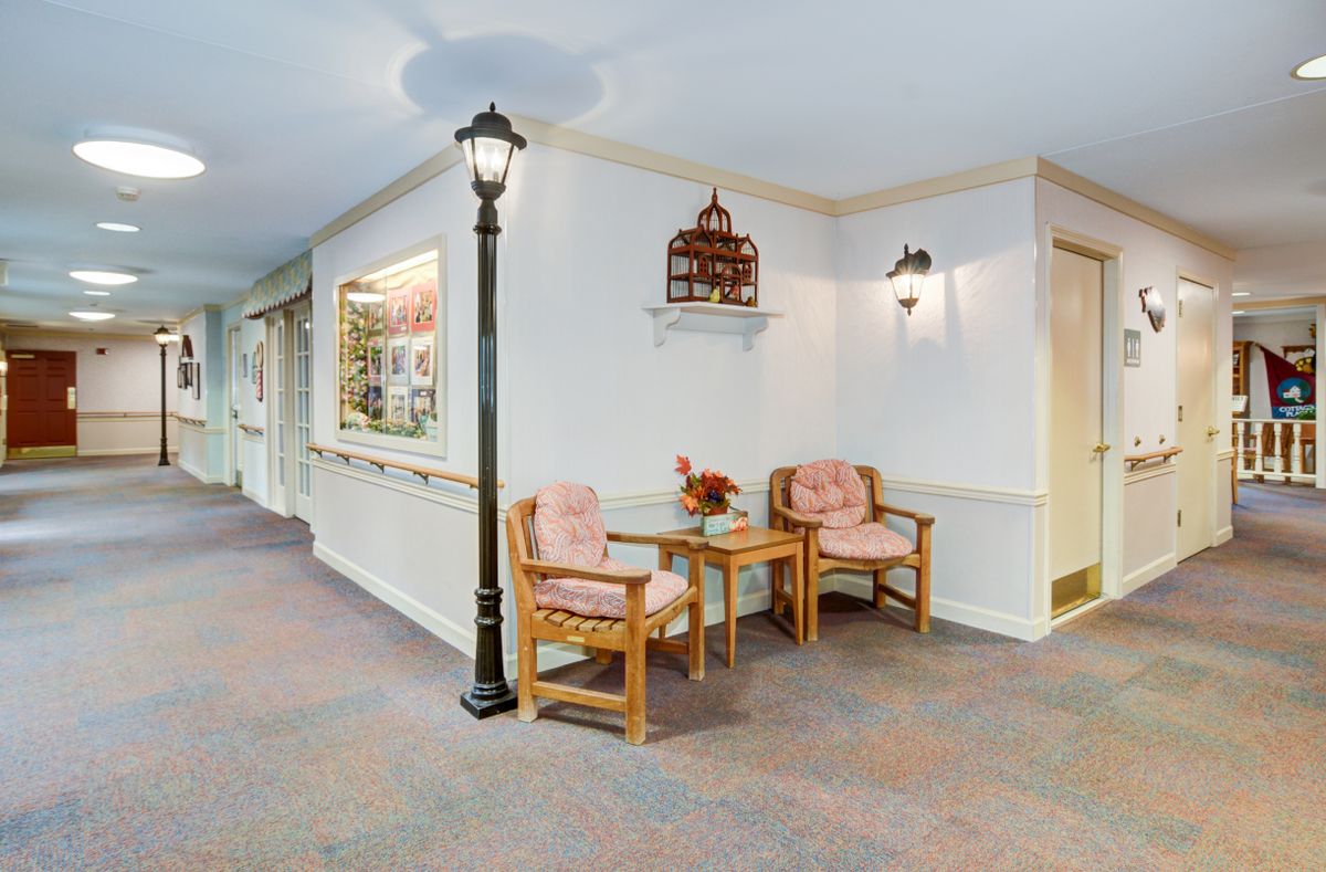 A cozy hallway with two chairs and a decorative lamp post.