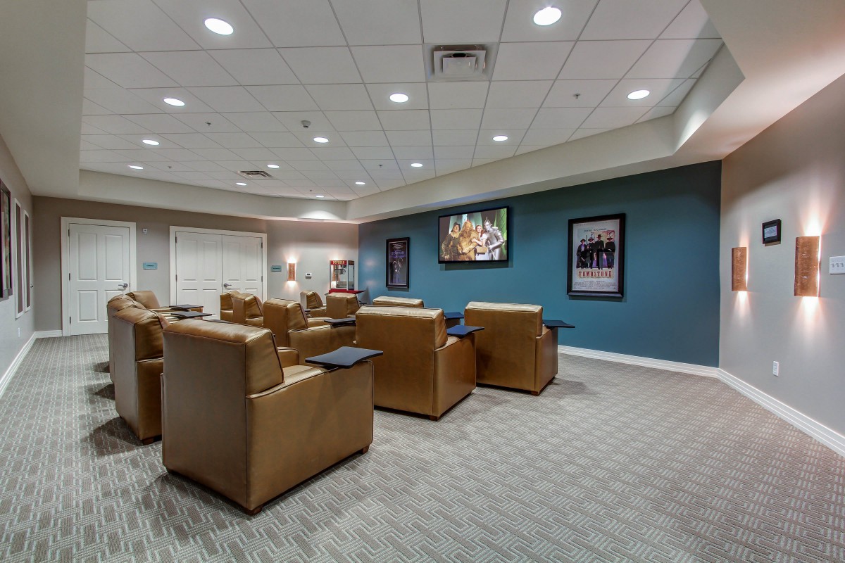 A modern waiting room with recliner chairs and a television.