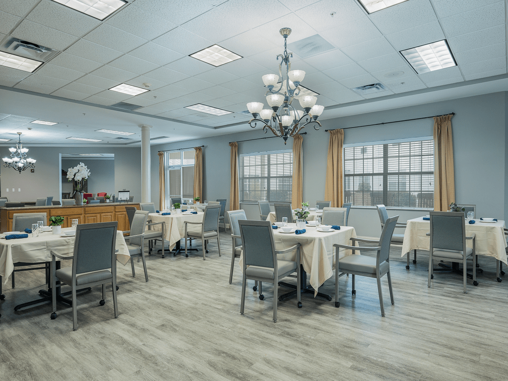 Spacious dining area with elegant chandeliers and neatly arranged tables and chairs.