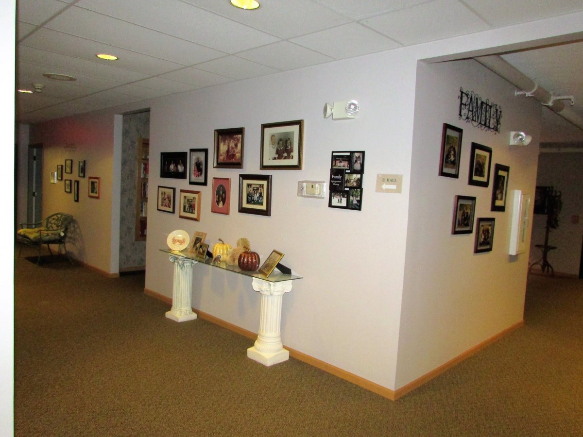 A hallway with art and photographs displayed on the walls.