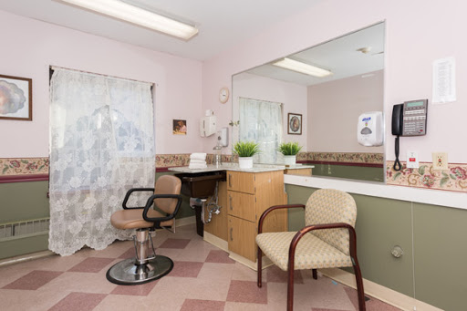 A cozy interior of a salon featuring a waiting area with stylish chairs and a large mirror.