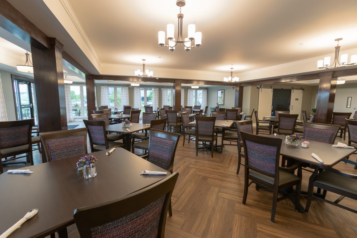An empty restaurant dining area with neatly arranged tables and chairs.