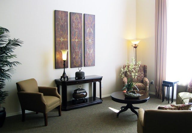 A cozy living room with elegant furniture and decorative artwork on the wall.
