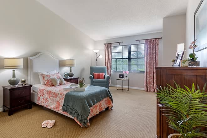 A cozy bedroom with a single bed, armchair, and decorative elements.