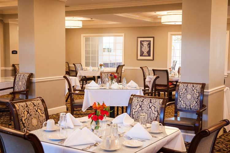 A beautifully set dining room with white tablecloths and elegant decor.