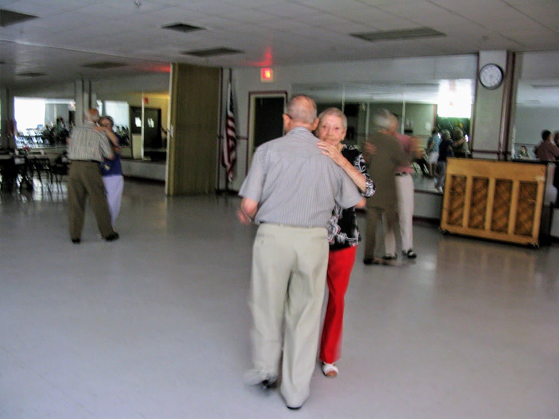 A couple dances together in a dance studio.