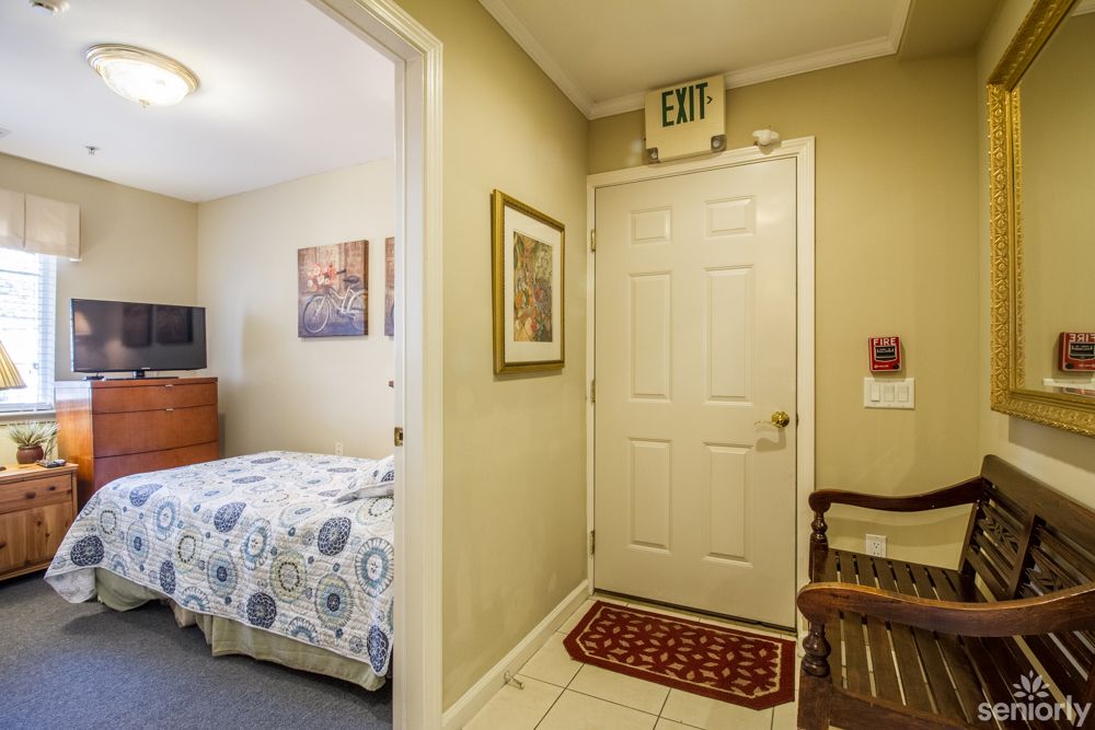 A cozy bedroom interior with a floral bedspread and an exit door.