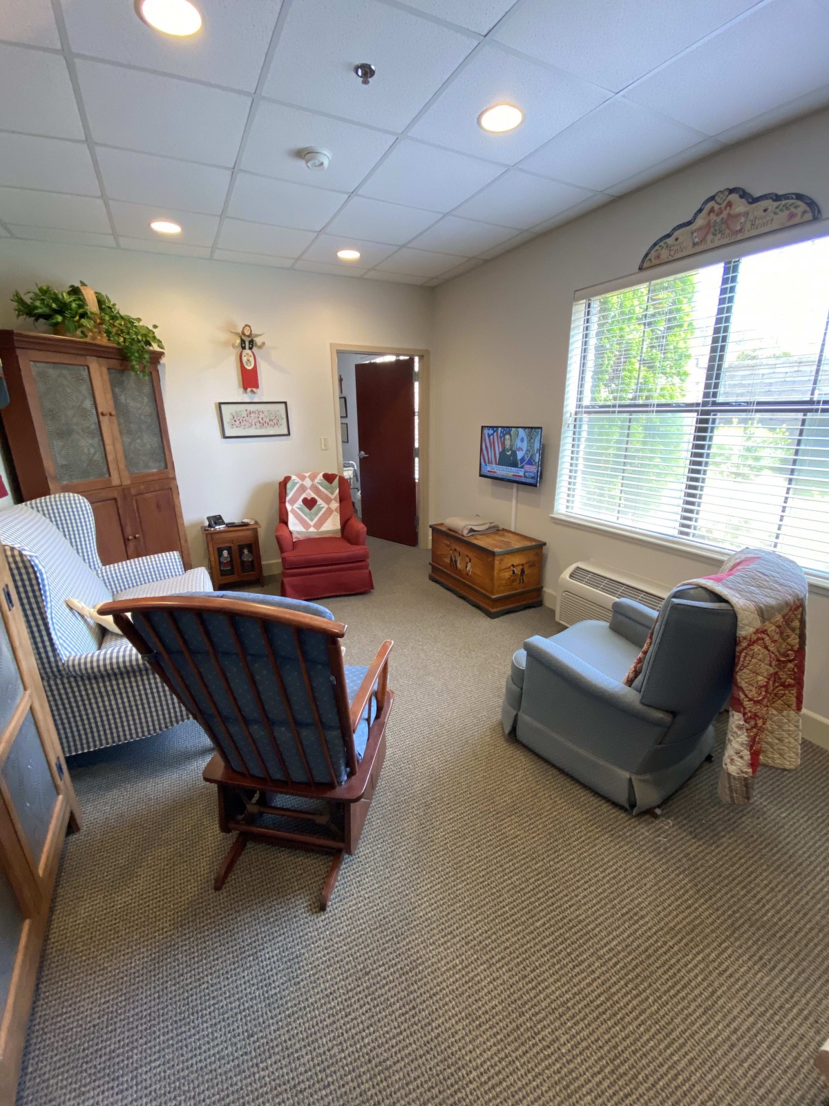 A cozy living room with various armchairs, a large window, and homey decor.