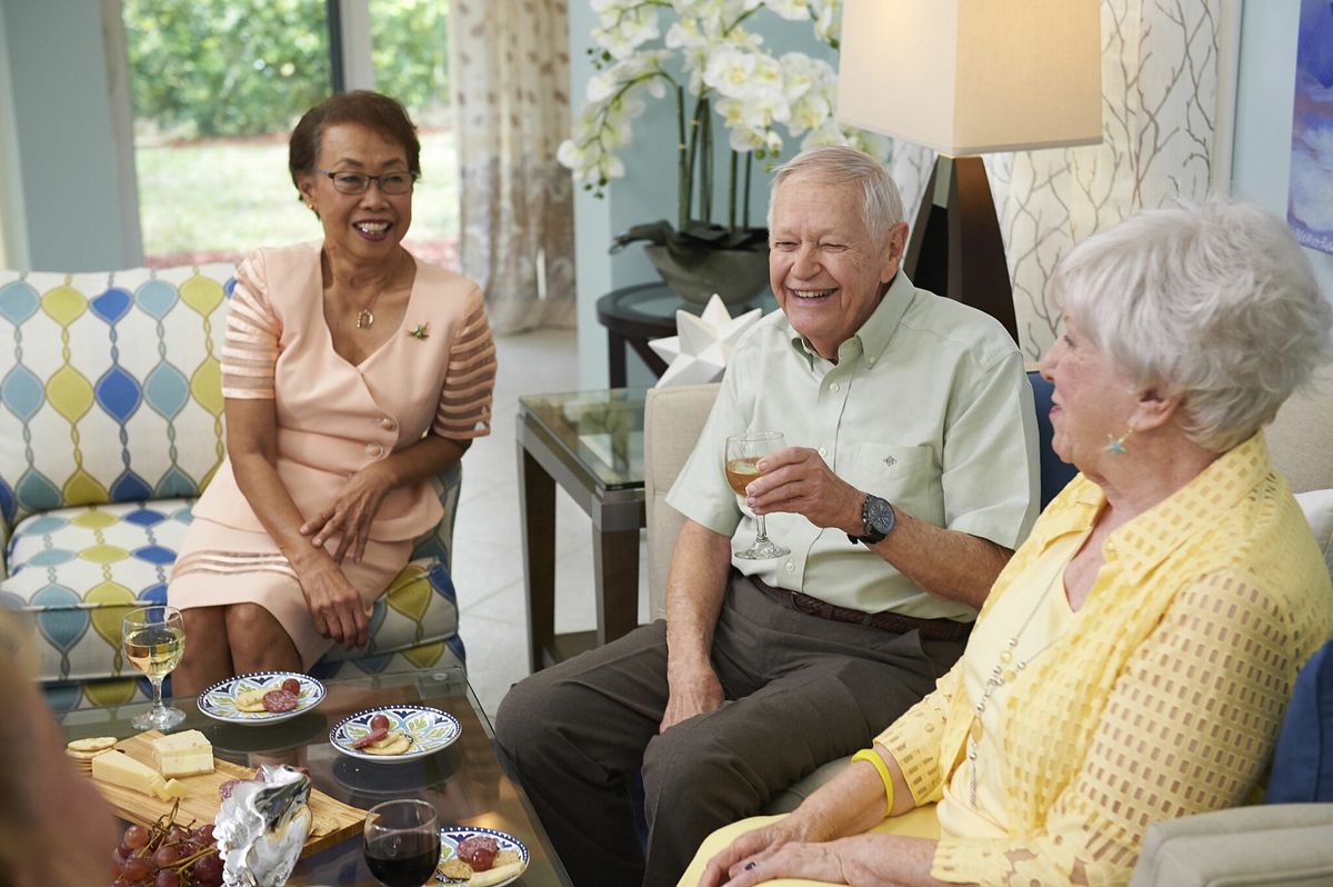 A group of seniors enjoying a lively conversation in a cozy living room setting.