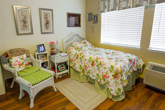 A cozy bedroom with a floral bedspread and decorative elements.