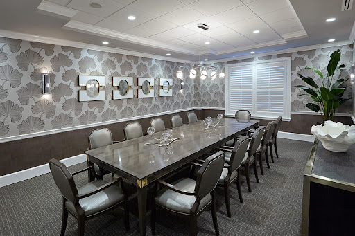 A well-designed conference room featuring a long table and comfortable seating, suitable for business meetings.