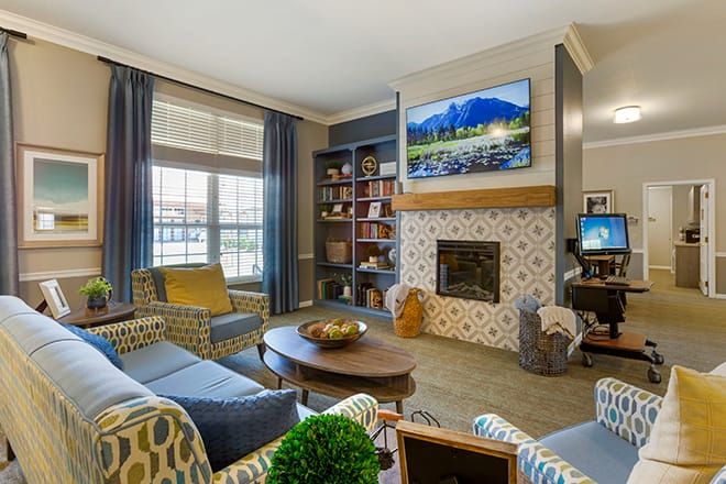 A cozy living room with a fireplace, bookshelves, and comfortable seating.
