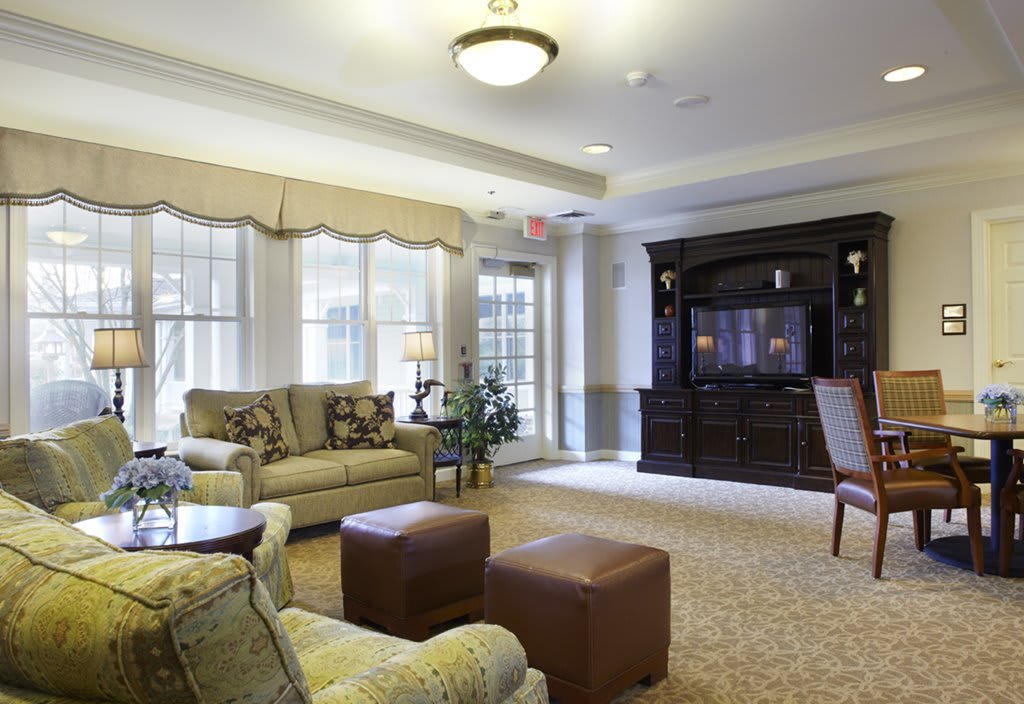 A cozy living room with comfortable seating, a large television, and ample natural light.