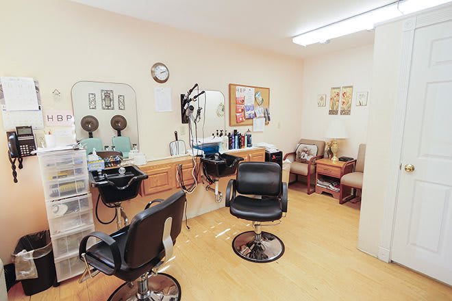 Interior of a hair salon with styling chairs and a waiting area.