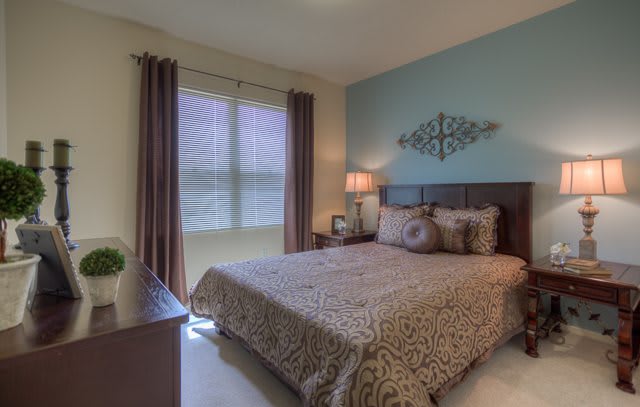 A cozy bedroom with stylish decor, featuring a large bed and soft lighting.