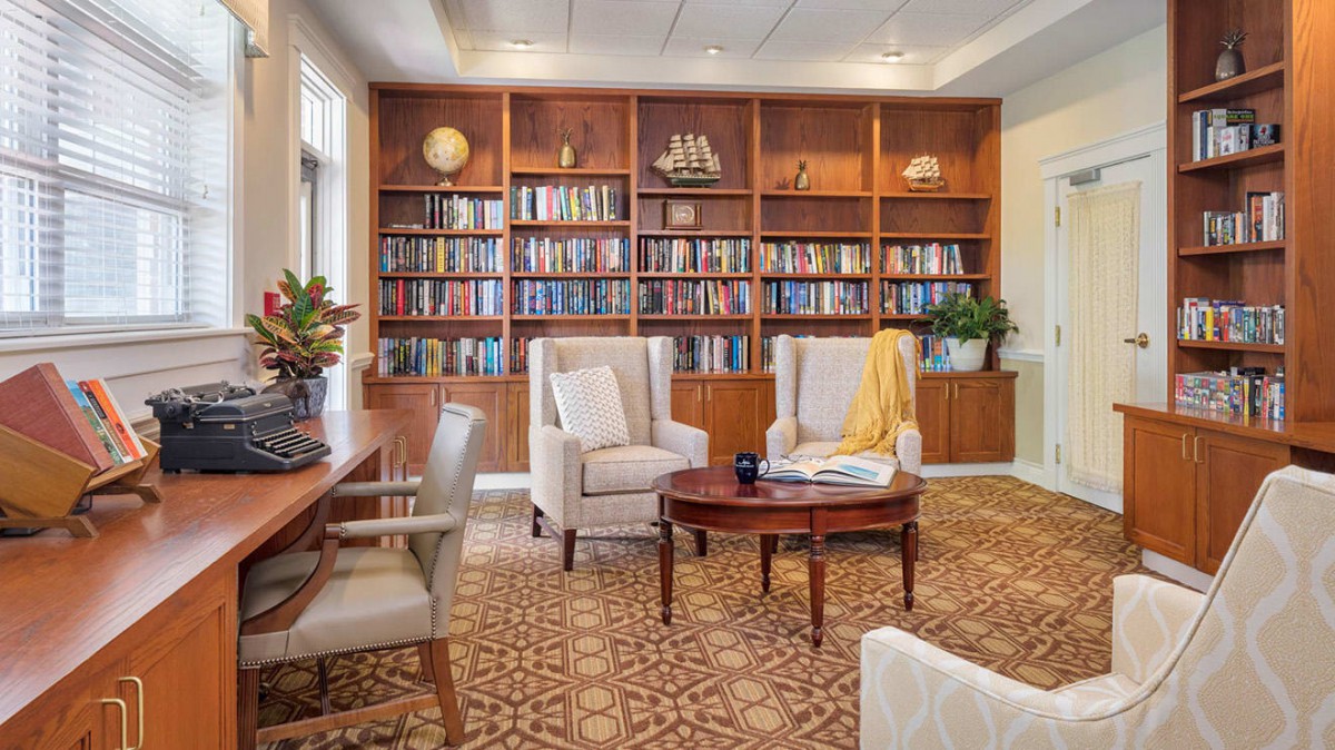 A cozy library with wooden bookshelves, comfortable seating, and a warm atmosphere.